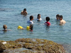 Uzak Doğulu turistler denize elbiseleriyle giriyor